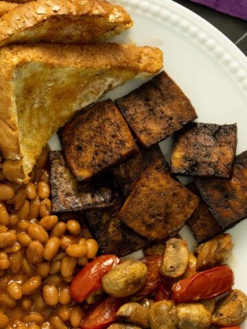 English-style breakfast on a white plate with vegan Canadian bacon