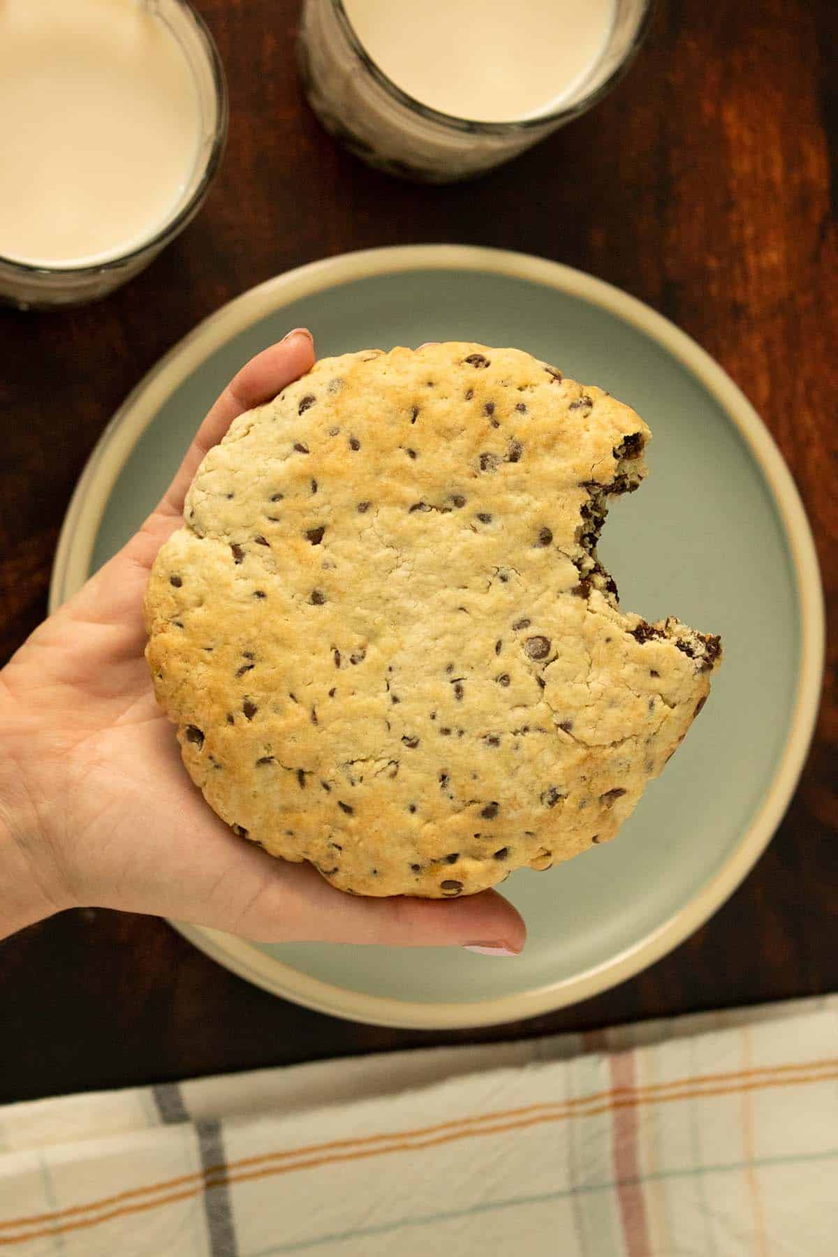 hand holding a giant, vegan air fryer cookie with a bite taken out