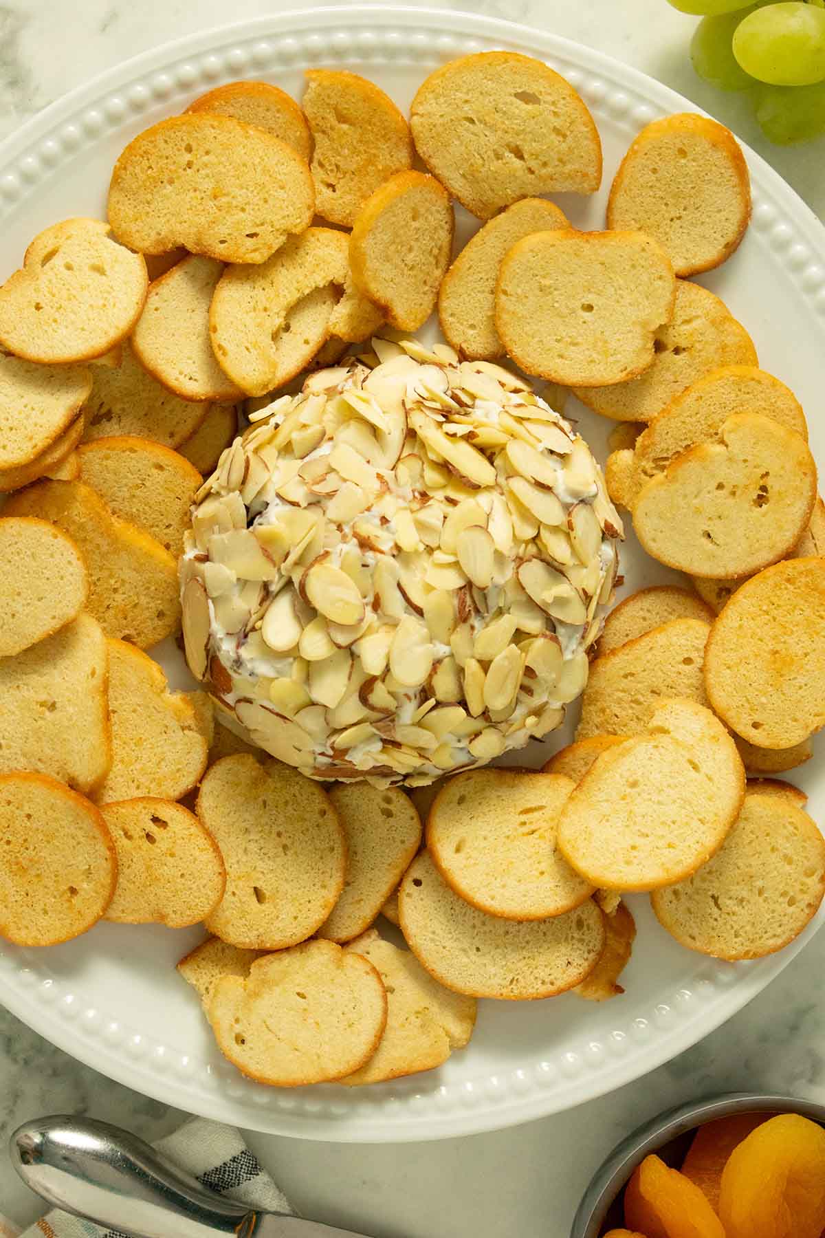 vegan cheese ball on a white plate with bagel chips