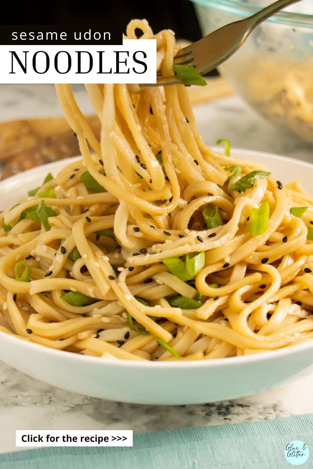 sesame udon noodles in a bowl with green onion, text overlay