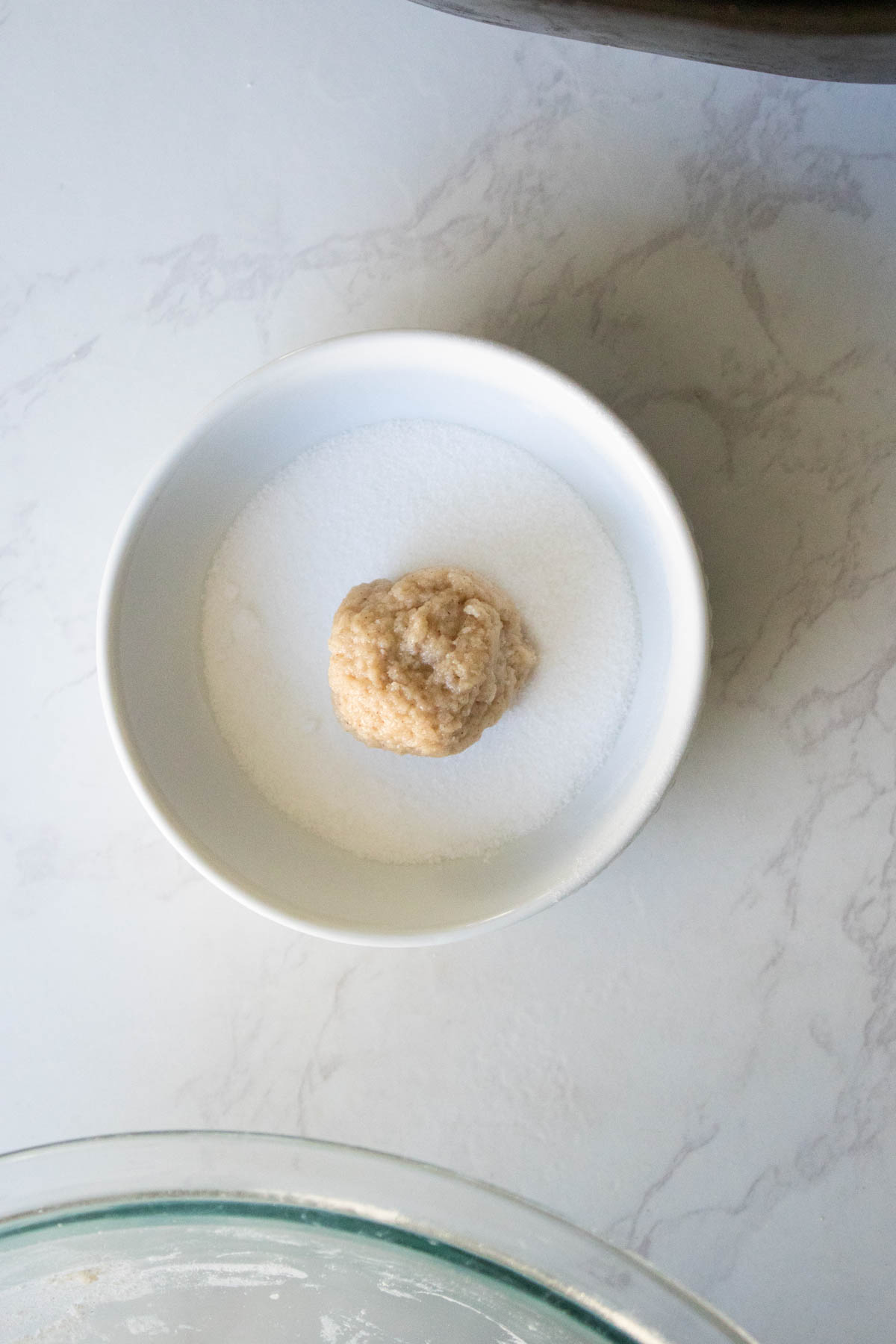 dredging a dough ball in sugar