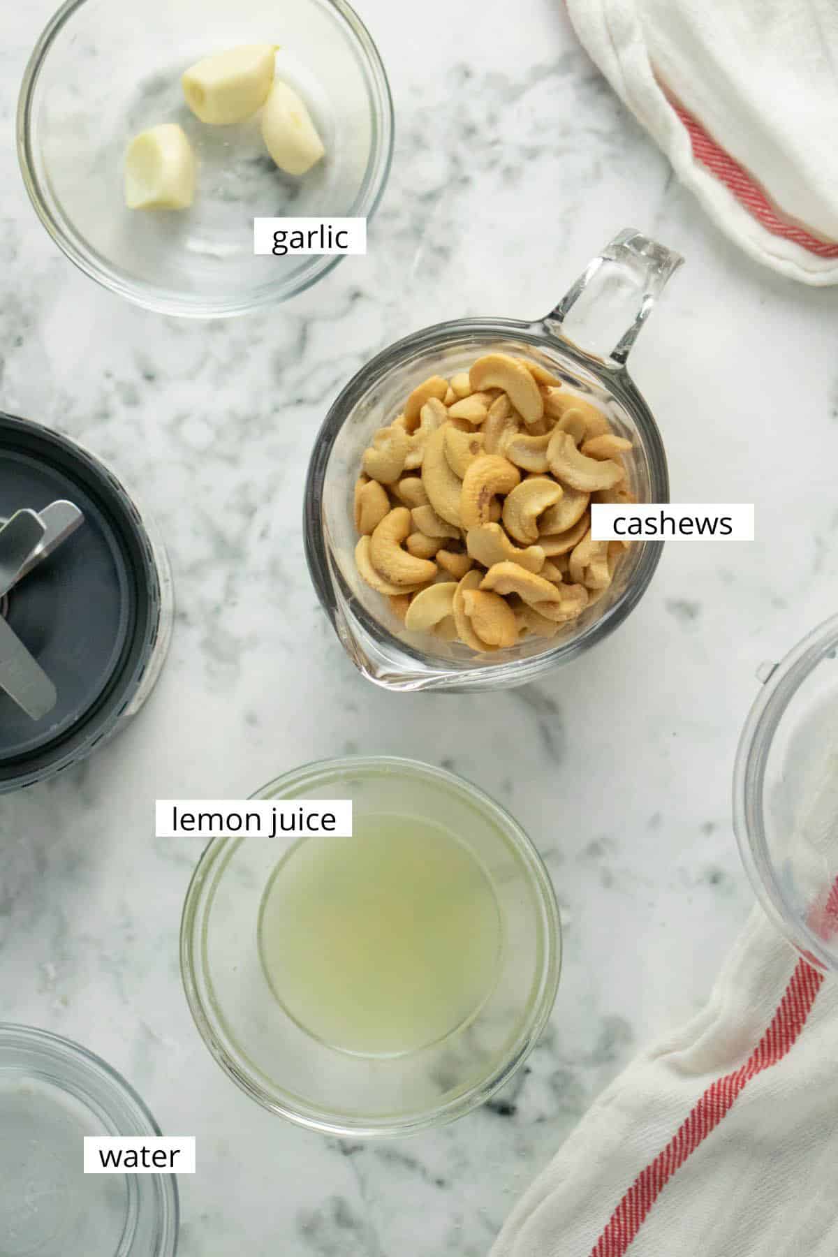 image collage of cashews, lemon juice, garlic, and water in bowls on a table with text labels