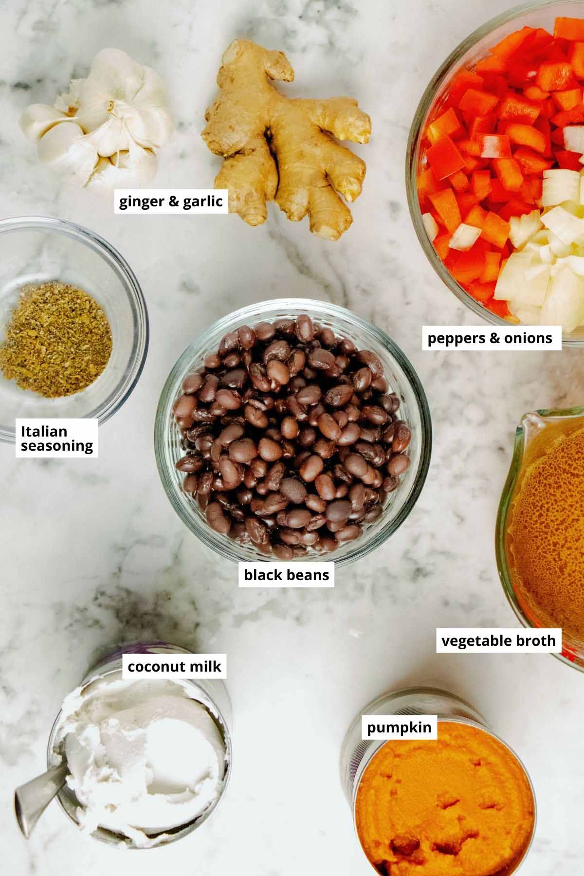 black beans, canned pumpkin, coconut milk, and other soup ingredients on a white table