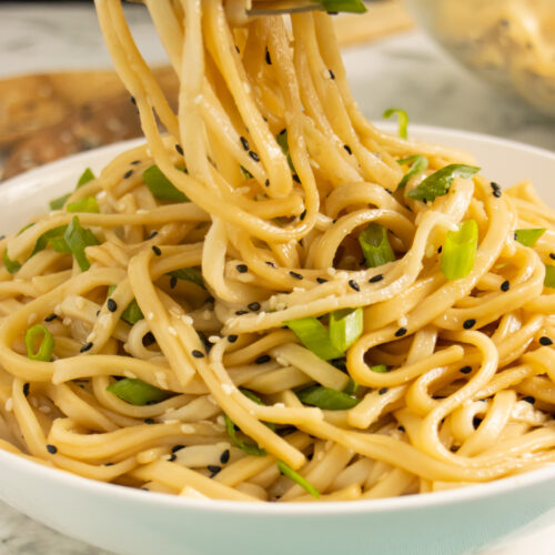 sesame udon noodles in a bowl with green onion