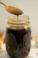 jar of teriyaki sauce with a spoon over it drizzling sauce