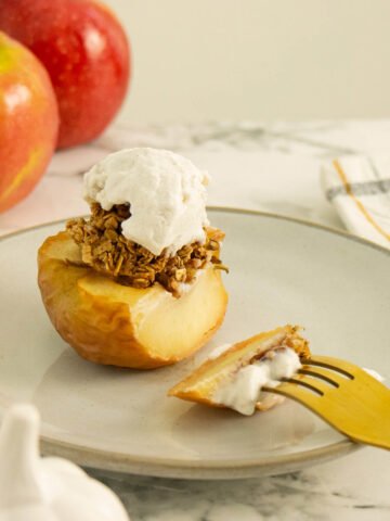 air fryer baked apples on a plate with vegan vanilla ice cream on it
