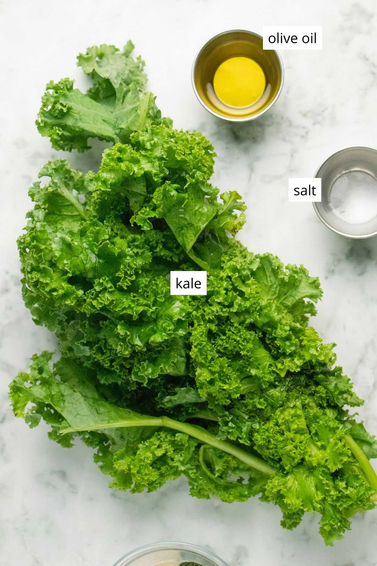 kale, olive oil, and salt on a marble table with text labels on each one