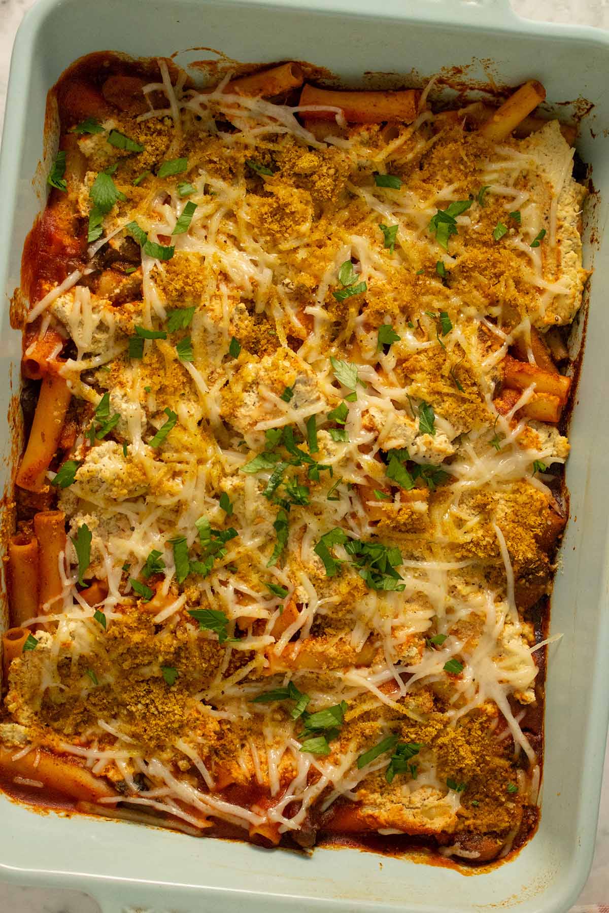 vegan baked ziti fresh out of the oven with parsley sprinkled on top