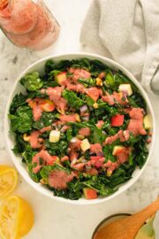 kale apple walnut salad in bowl on a marble table