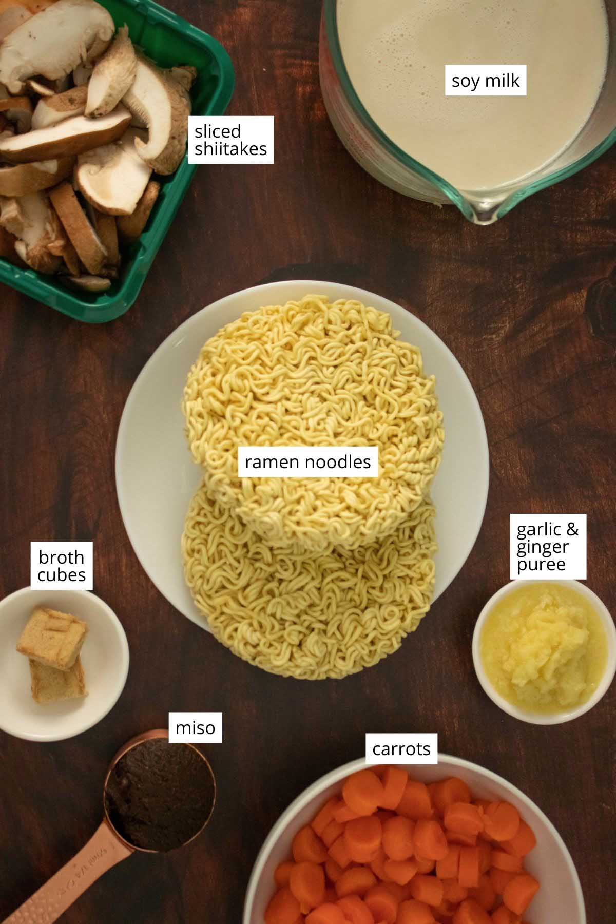 ramen noodles and broth ingredients in bowls on a wooden table