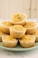 vegan cornbread muffins piled onto a blue plate