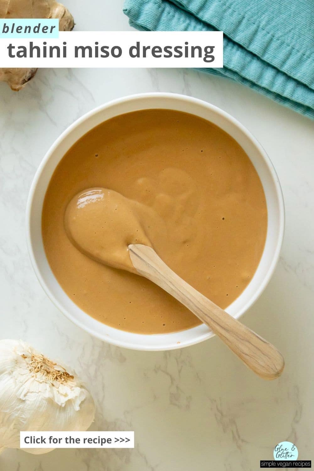 white bowl of tahini miso dressing with a spoon in it, so you can see the creamy texture. Text overlay