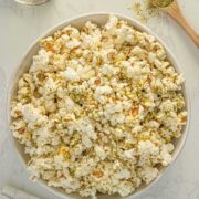 bowl of ranch popcorn with a spoon of ranch popcorn seasoning next to it