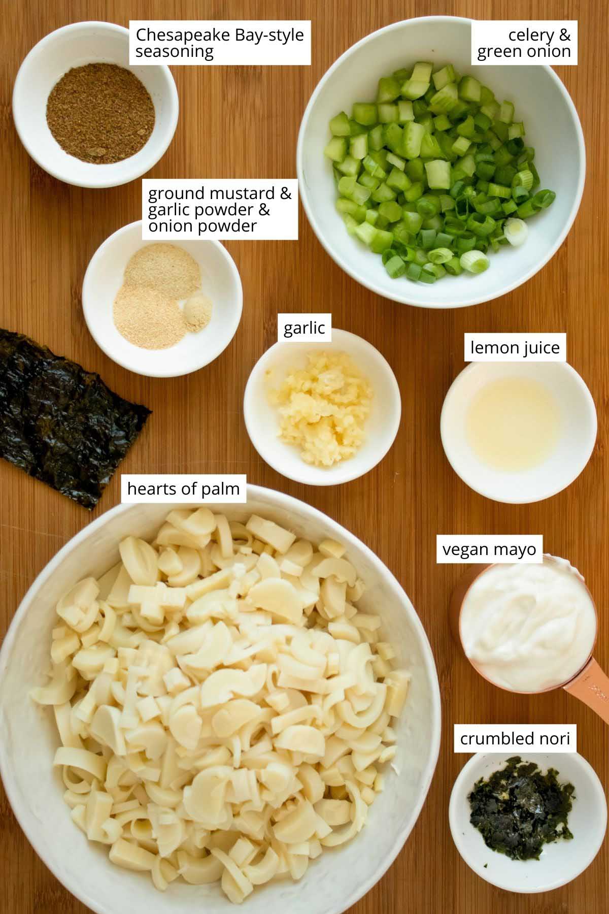 hearts of palm and dressing ingredients in bowls on a wooden table