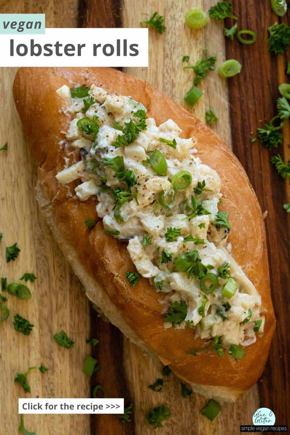 close-up of a vegan lobster roll on a wooden tabletop sprinkled with green onion and parsley, text overlay