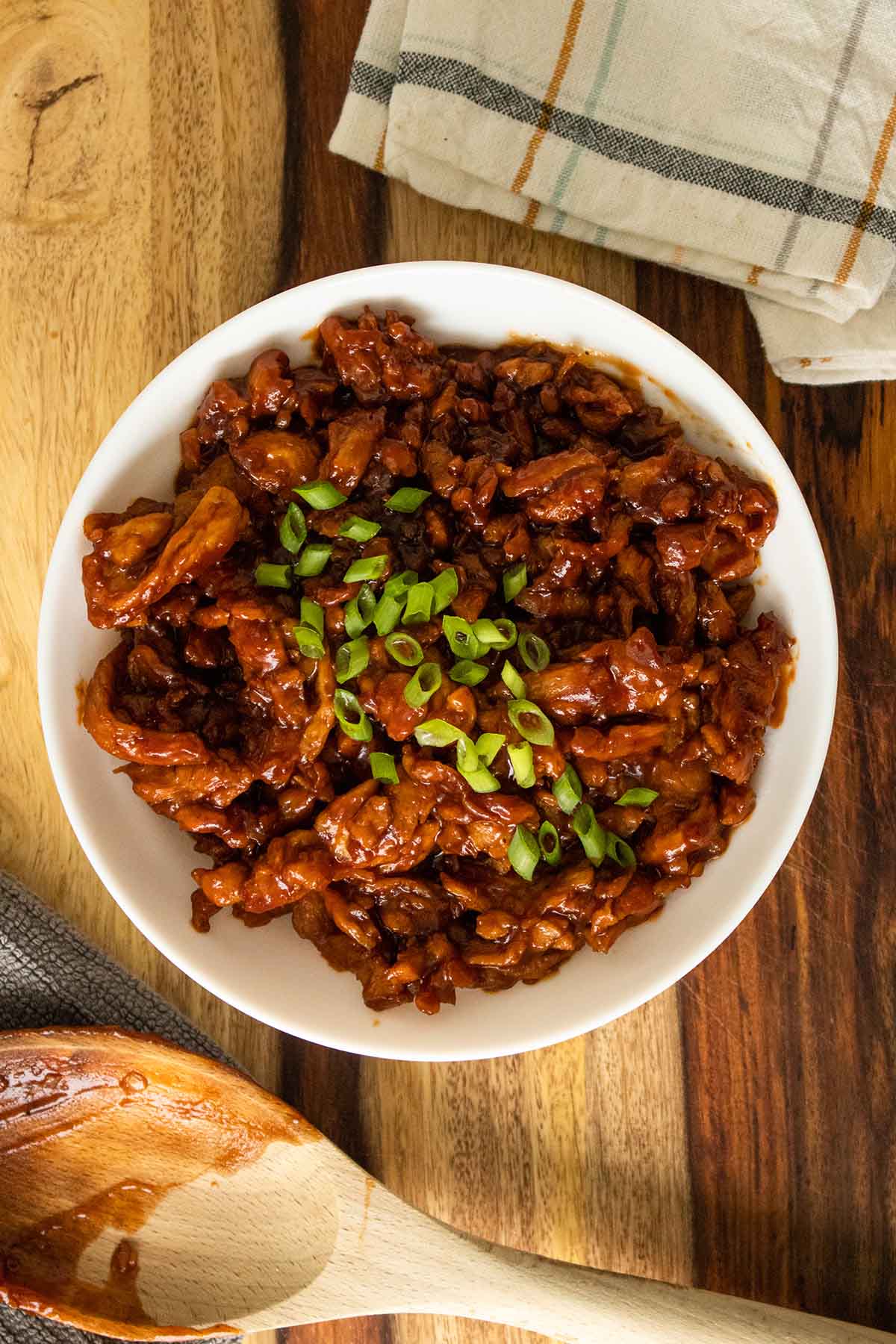 BBQ soy curls in a bowl with green onions on top