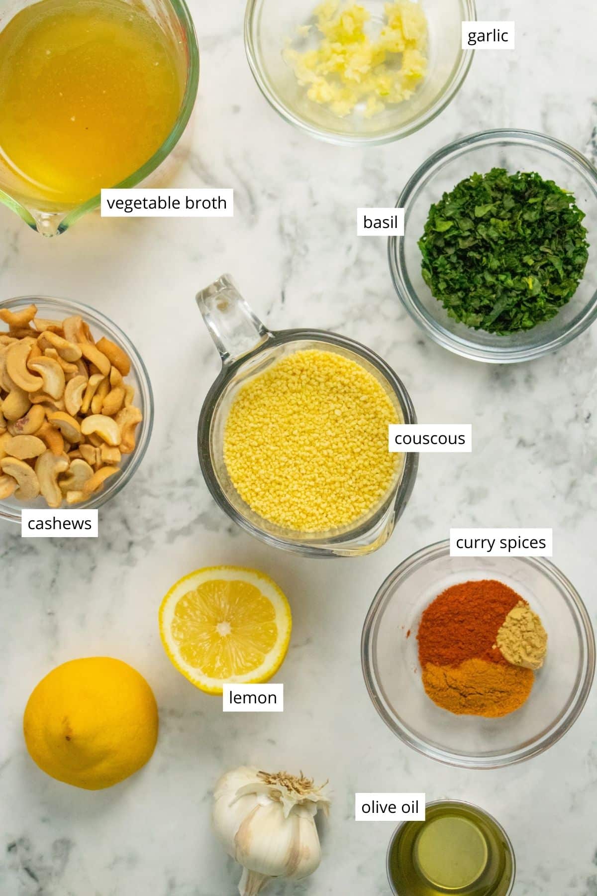 couscous, cashews, and seasonings in bowls on a kitchen countertop