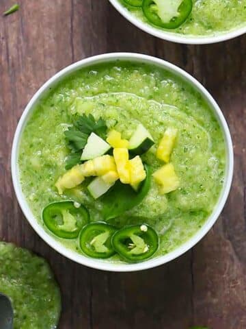 pineapple gazpacho in a bowl topped with chopped fresh pineapple, cucumber, jalapeno, and cilantro