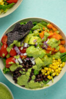 vegan taco salad with veggies, beans, corn, tortilla chips, and chimichurri