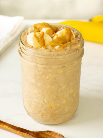 jar of banana and peanut butter overnight oats with slices of banana and a peanut butter drizzle on top