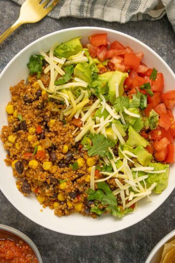instant pot quinoa burrito bowl with corn, beans, avocado, tomato, vegan cheese, and cilantro