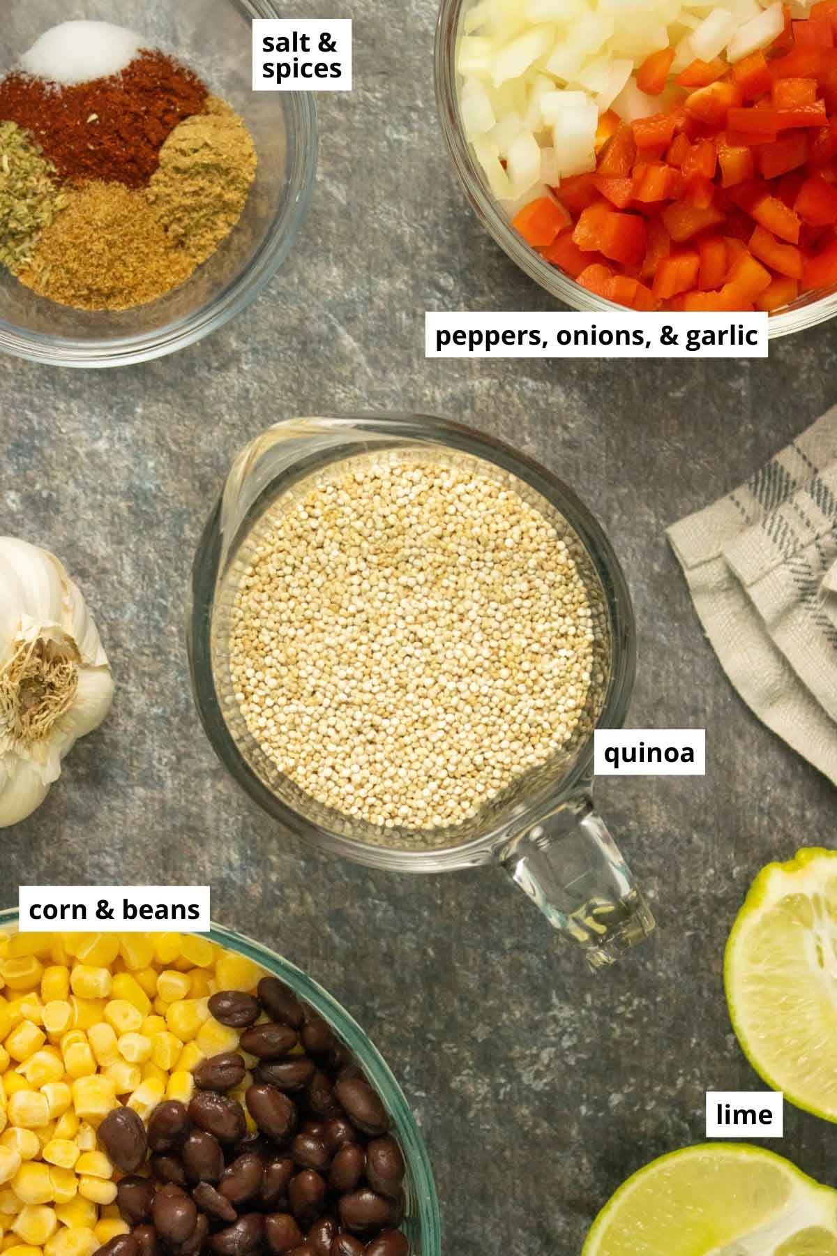 quinoa, beans, veggies, and spices in bowls on a slate table