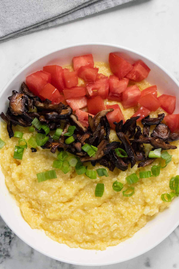 shiitake bacon served over grits with tomato and green onion