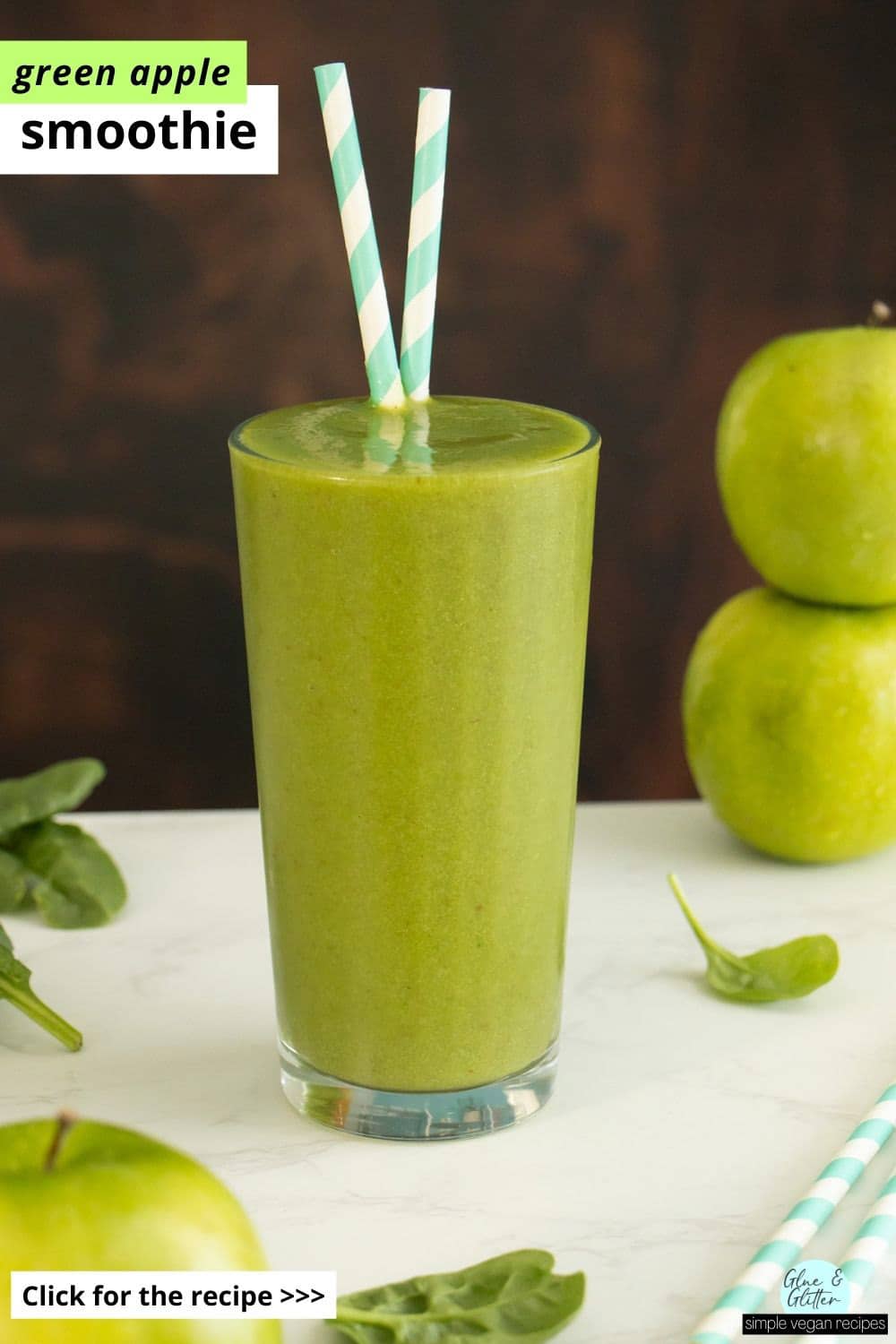 green apple smoothie in a glass with apples and spinach on the table around it, text overlay