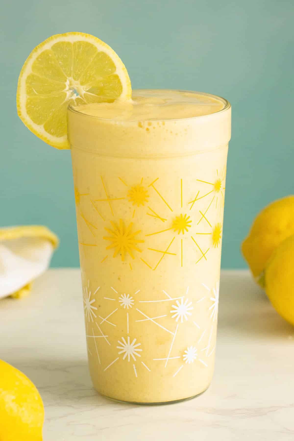 lemon smoothie in a glass with a lemon wheel