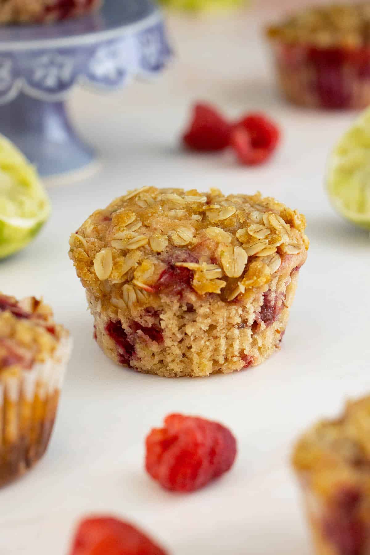 vegan raspberry muffins on a table with raspberries around them