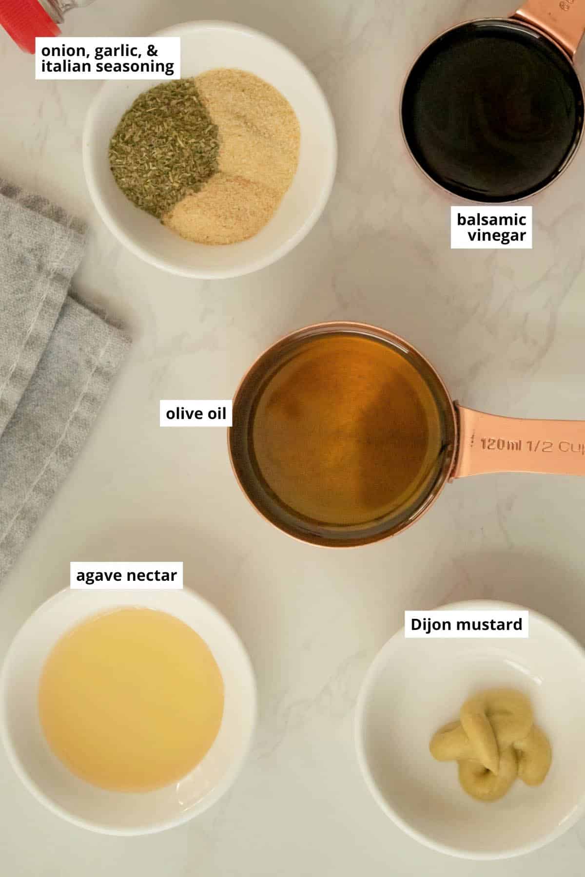 balsamic vinaigrette ingredients in cups on a white table