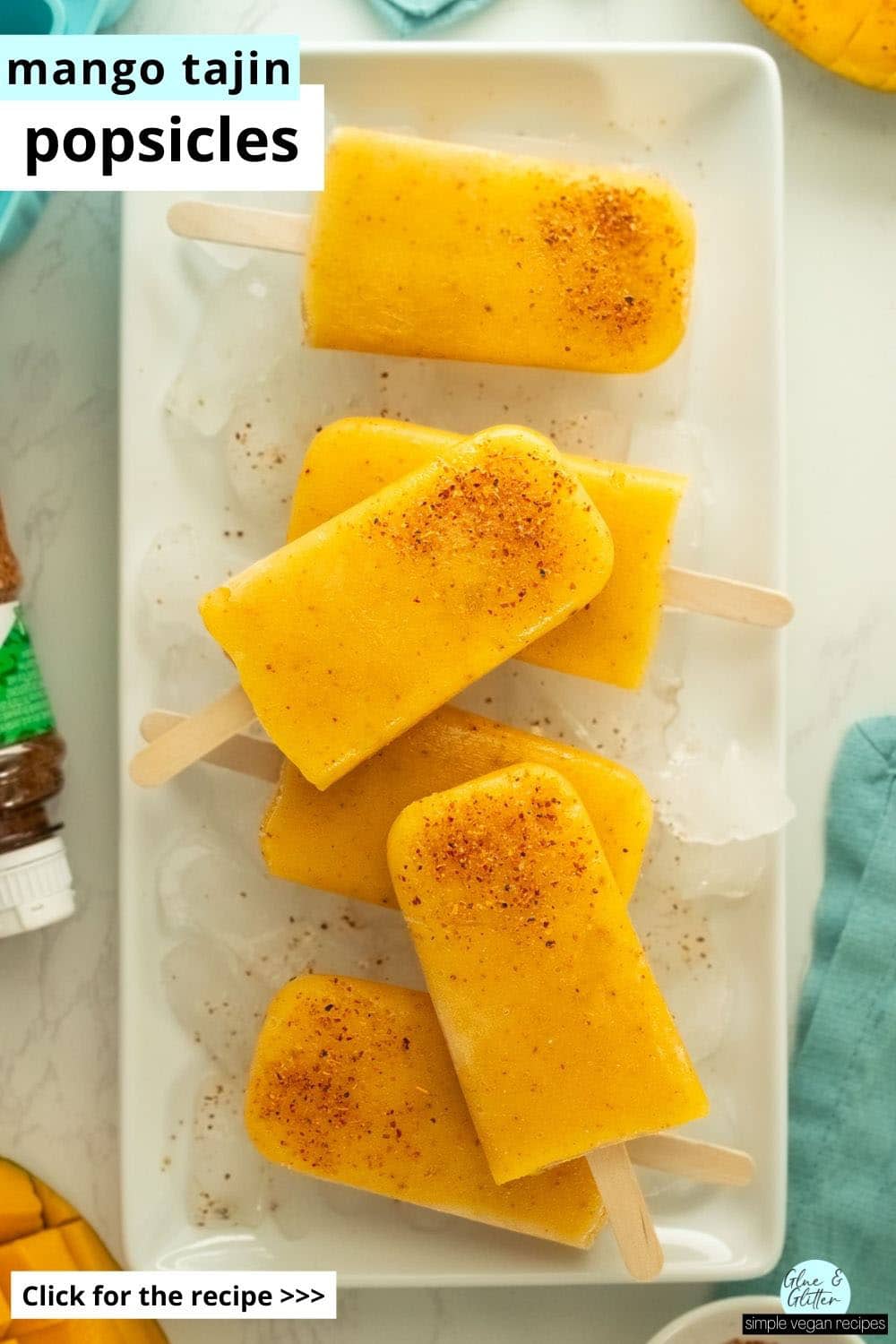mango tajin popsicles on a serving tray covered in ice, text overlay