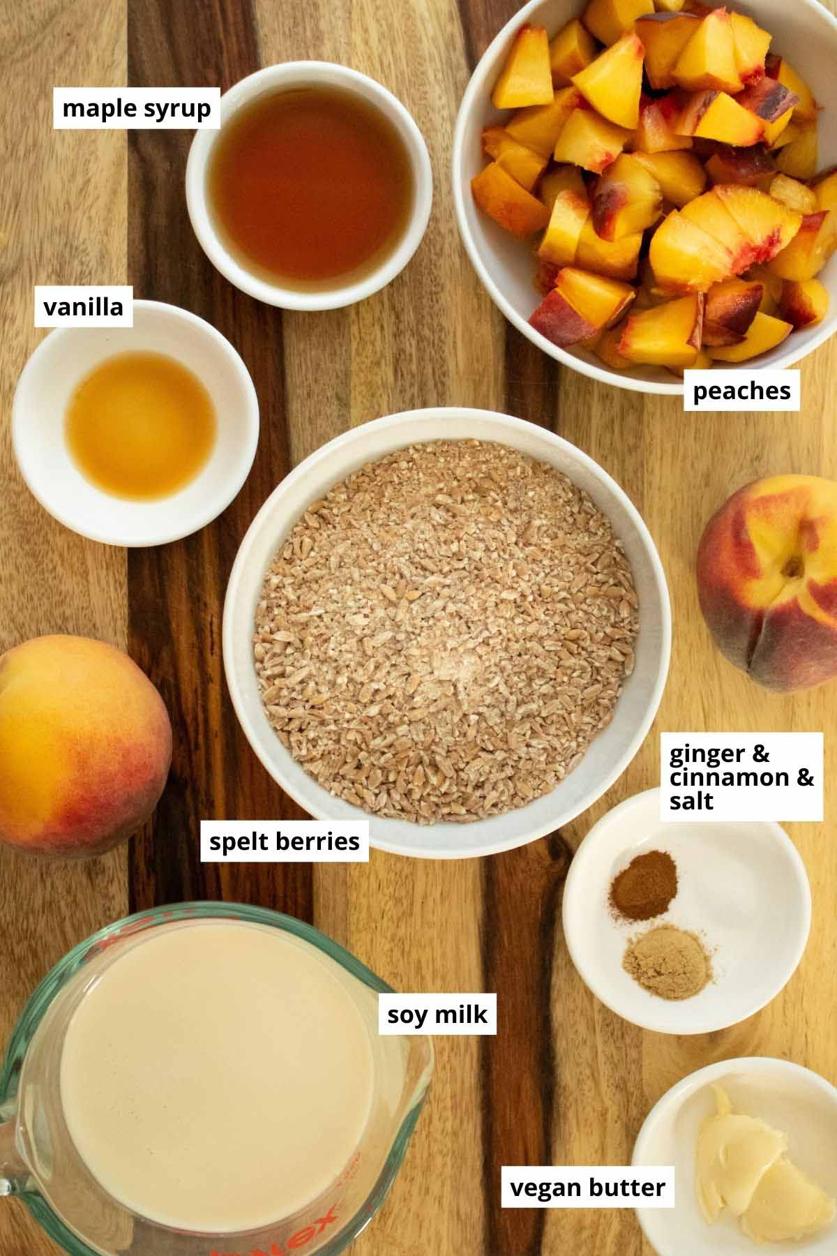 ground spelt berries, peaches, and other oatmeal ingredients on a wooden table