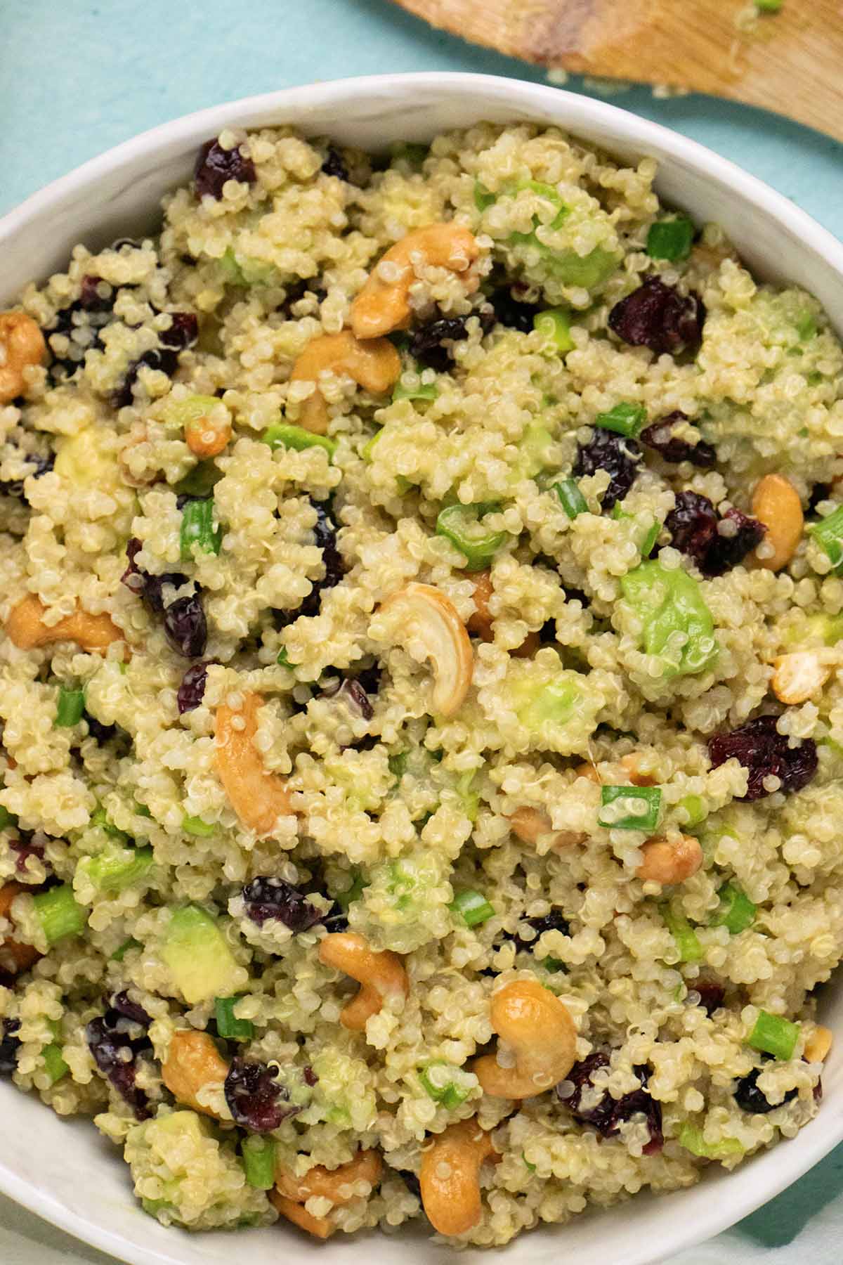close-up of a bowl of citrus quinoa salad with cranberries, cashews, and avocado