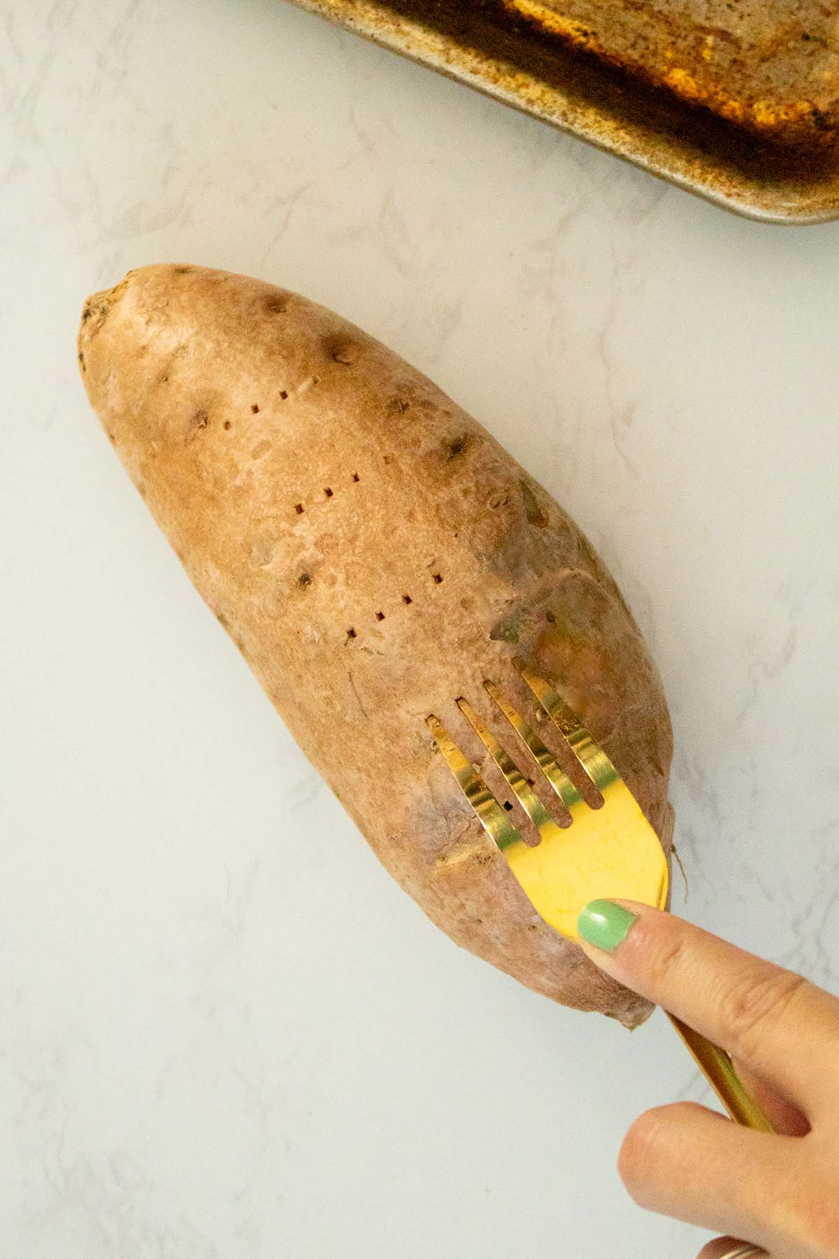 piercing a sweet potato with a fork