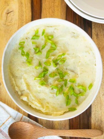 cauliflower mashed potatoes after mixing and mashing together, topped with green onions