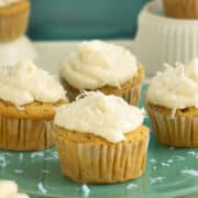 vegan coconut cupcakes with coconut cream cheese frosting on a blue plate