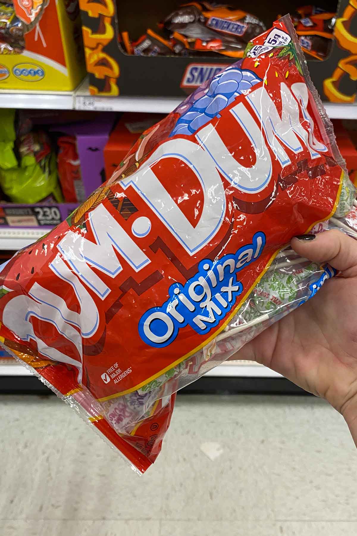 hand holding a bag of Dum Dums lollipops