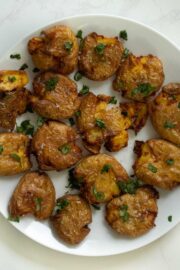 air fryer smashed potatoes topped with sea salt and fresh herbs