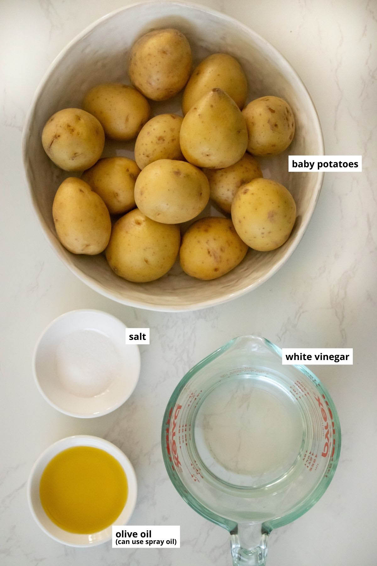 new potatoes, salt, oil, and vinegar in bowls and cups
