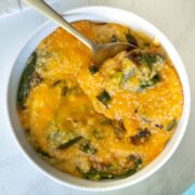 bowl of vegan cheese grits casserole with a spoon