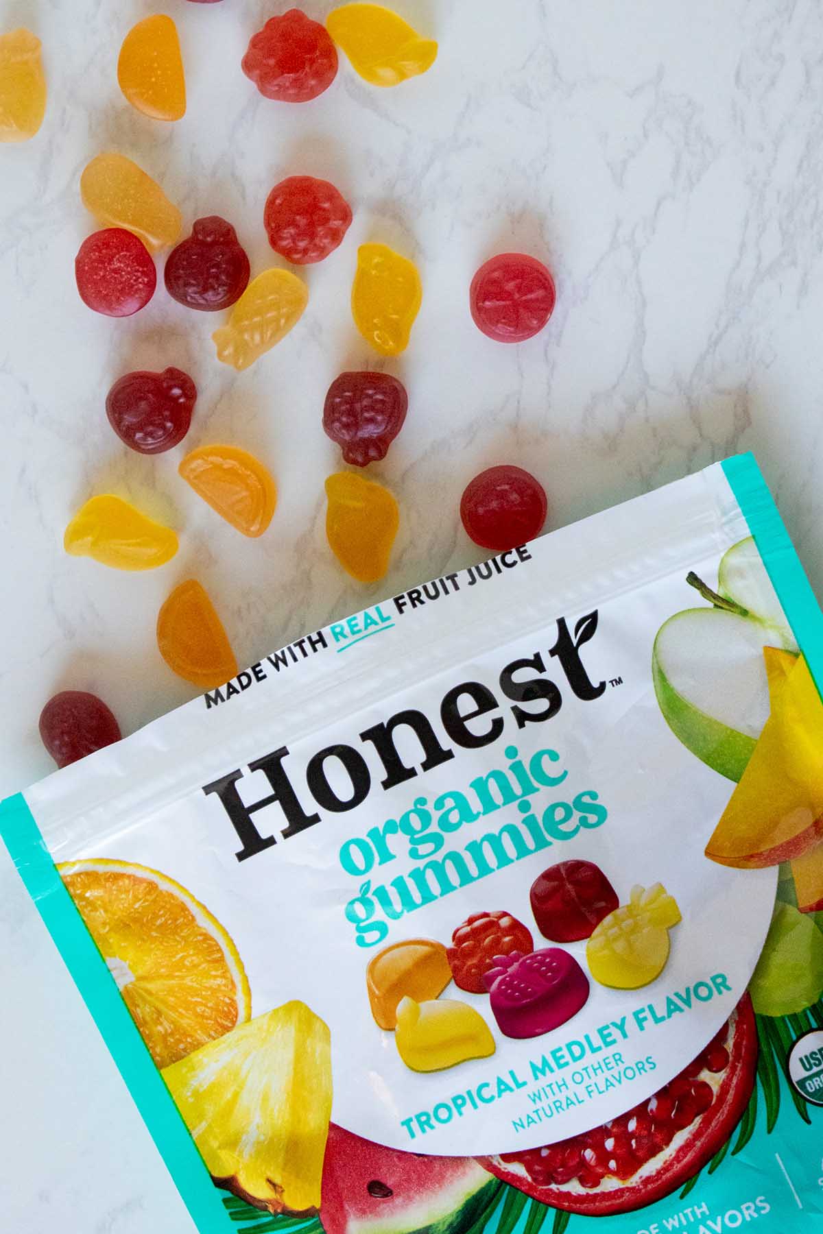 bag of Honest organic vegan gummies with gummies spilling out onto the table