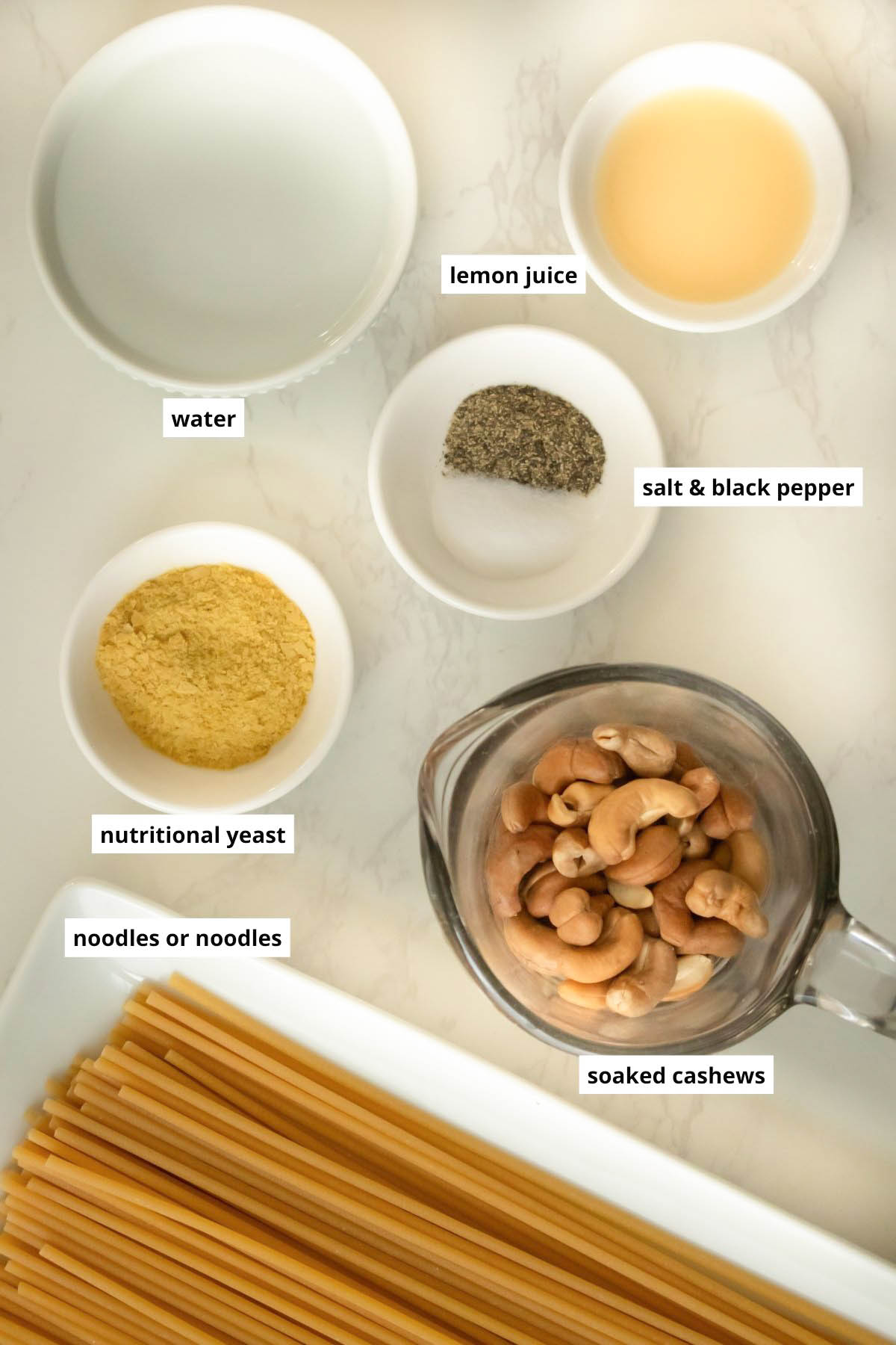 salt, pepper, pasta, and other ingredients on a white table