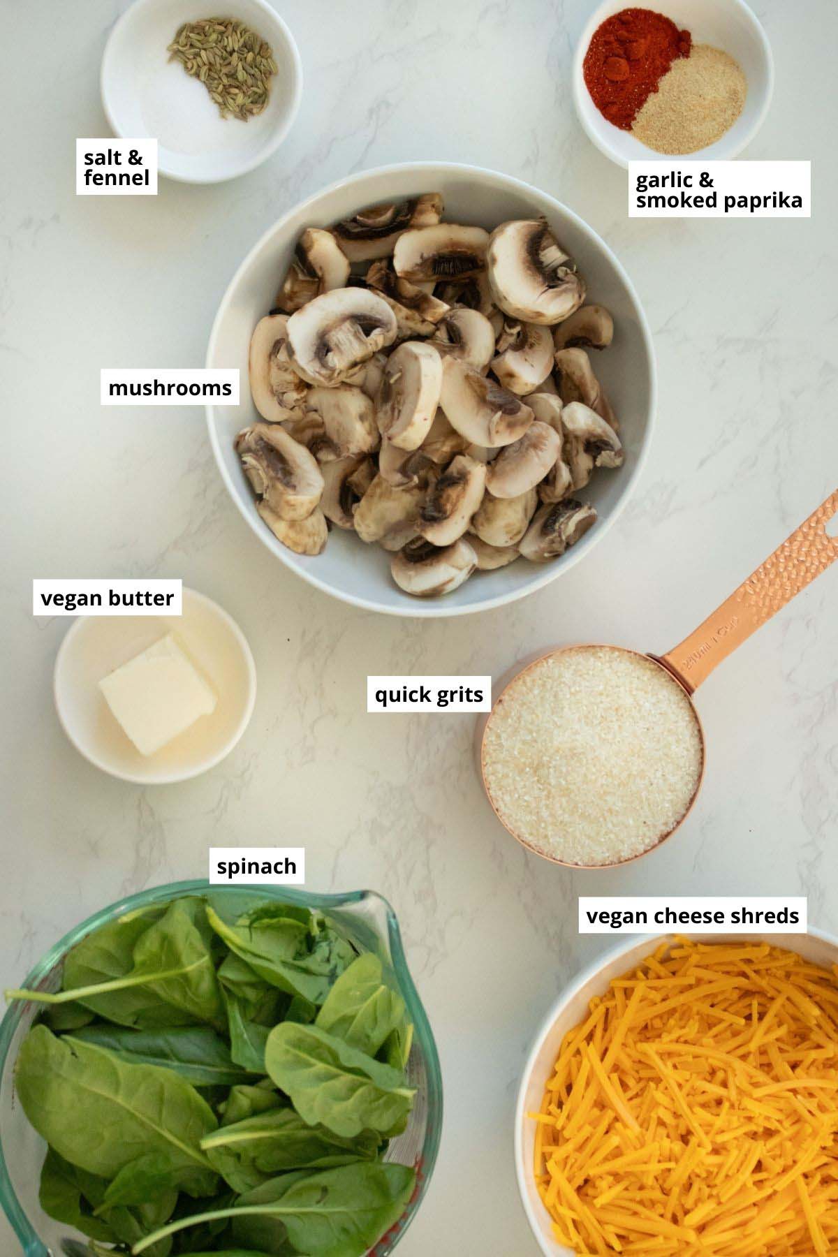grits, vegan cheese, mushrooms, and other grits casserole ingredients in bowls on a white table