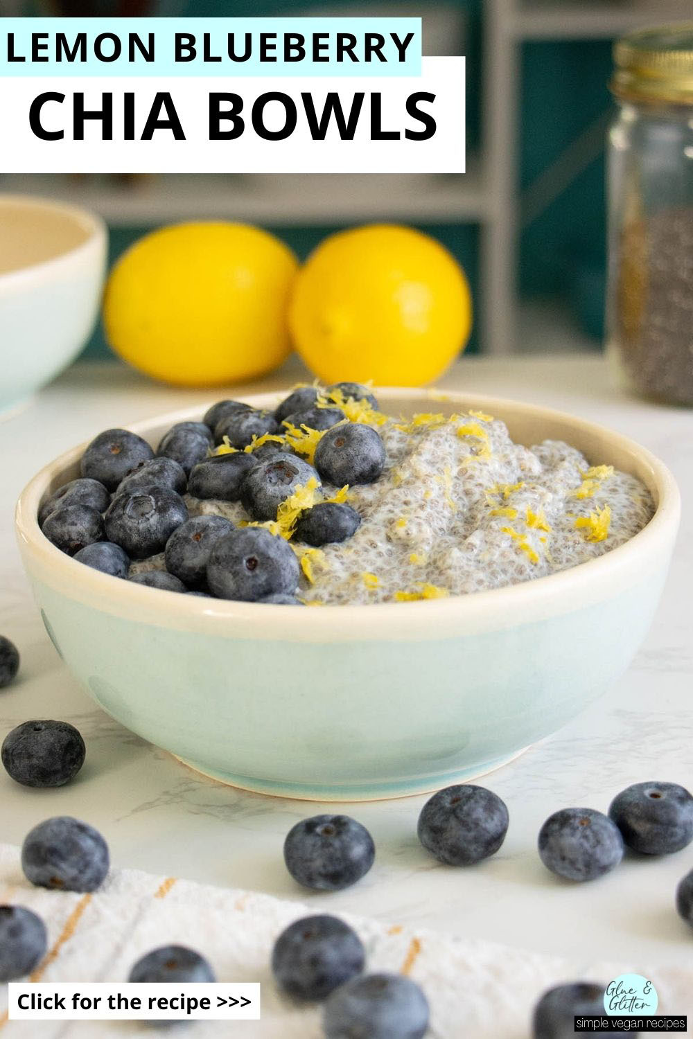 lemon blueberry chia pudding in a bowl on a white table with lemons, berries, and chia seeds around it, text overlay