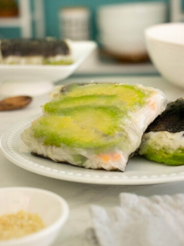 rice paper sushi with avocado and pickled carrots on a white plate