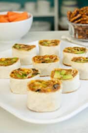 vegan pinwheels on a serving platter as part of a party spread