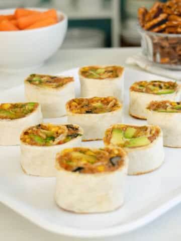 vegan pinwheels on a serving platter as part of a party spread