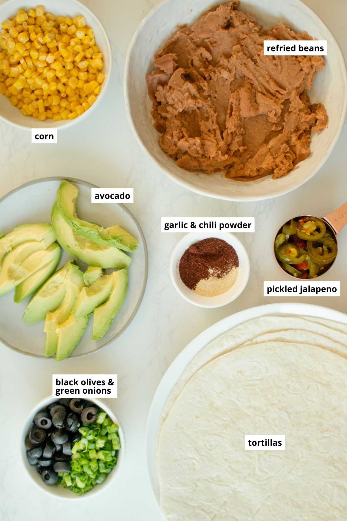 tortillas and bowls of filling ingredients for vegan pinwheels