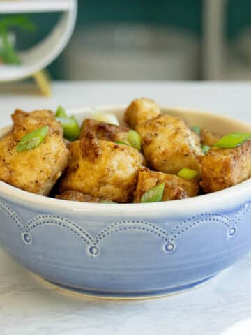 air fryer salt and pepper tofu in a bowl with green onions on top